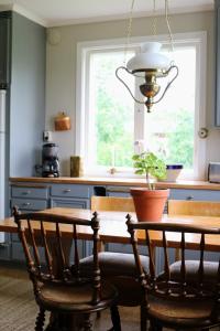 una cucina con tavolo, sedie e finestra di Familjevänligt hus med stor trädgård a Vallsta