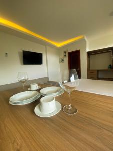 Cette chambre comprend une table avec des assiettes et des verres à vin. dans l'établissement Pacific Suites Guayaquil Airport, à Guayaquil