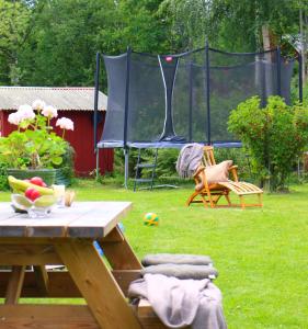 una mesa de picnic en un patio con una tienda de campaña en Familjevänligt hus med stor trädgård en Vallsta