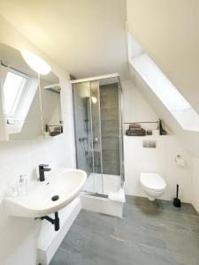 ein weißes Bad mit einem Waschbecken und einem WC in der Unterkunft Pension Trautheim in Bad Harzburg
