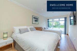 two beds in a white bedroom with a window at Dwellcome Home Ltd 5 Bed 3 Bath Aberdeen House - see our site for assurance in Aberdeen