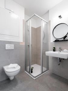 a bathroom with a shower and a toilet and a sink at limehome Klagenfurt Goessgasse in Klagenfurt