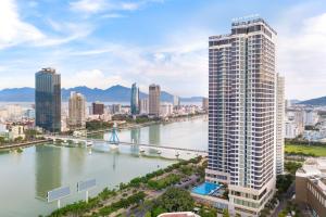 Blick auf eine Stadt mit Fluss und Brücke in der Unterkunft Meliá Vinpearl Danang Riverfront in Đà Nẵng