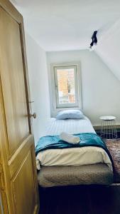 ein kleines Schlafzimmer mit einem Bett und einem Fenster in der Unterkunft Efren's cosy house in Brügge