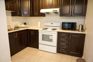 a kitchen with wooden cabinets and a white stove top oven at Peace Alcove in Milton