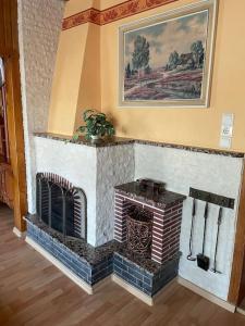 a brick fireplace in a room with a painting at Ferienwohnung in Golßen/Spreewald, Tropical Island in Golßen