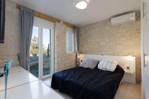1 dormitorio con cama y ventana grande en Komfortvilla sensationeller Meerblick priv. Pool en Agia Triada