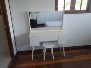 a white dressing table with a stool and a mirror at Private Luxury Villa in private beach resort in Telukmataikan