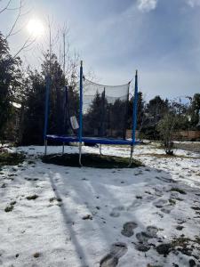 a swing set in the snow with the sun behind it at Hermosa y confortable casita en Bariloche in San Carlos de Bariloche