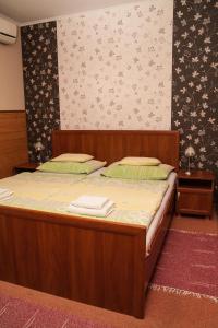 ein Schlafzimmer mit einem Holzbett mit Handtüchern darauf in der Unterkunft Korona Home in Sárvár