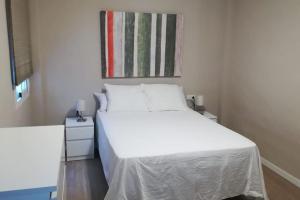 - une chambre avec un lit blanc et une fenêtre dans l'établissement Apartamento Cuarzo, à Séville