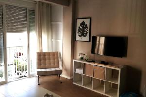 un salon avec une télévision et une chaise dans l'établissement Apartamento Cuarzo, à Séville