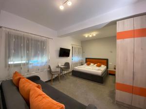 pokój hotelowy z łóżkiem i kanapą w obiekcie Orange House Constanta w Konstancy