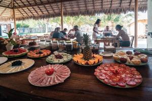 una mesa con muchos platos de comida. en Beekite Wind Village, en Luís Correia