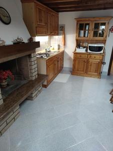 a large kitchen with wooden cabinets and a fireplace at Pellestrina Vacanze in Pellestrina