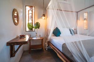 a bedroom with a bed and a table and a mirror at Beekite Wind Village in Luis Correia