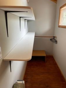 um pequeno quarto com uma prateleira e um banco em Hermosa y confortable casita en Bariloche em San Carlos de Bariloche