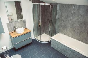 a bathroom with a shower and a tub and a sink at Swallows Rest in Montgomery