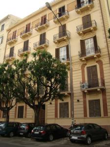 een groot gebouw met auto's geparkeerd voor het bij Ai Vicerè in Palermo