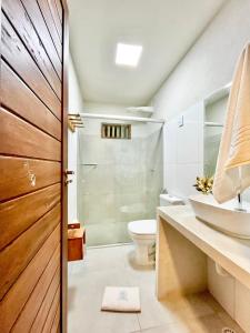 a bathroom with a shower and a toilet and a sink at Condomínio Praias de Maragogi & Casas Deluxe in Maragogi