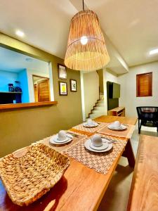 a wooden table with plates and bowls on top of it at Condomínio Praias de Maragogi & Casas Deluxe in Maragogi