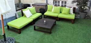 - un ensemble de chaises vertes et d'une table sur une terrasse dans l'établissement Vue sur Chateau et Loire, à Saumur