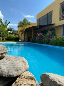 - une piscine avec des rochers en face d'une maison dans l'établissement Bio Casa Inusual, à Girardot