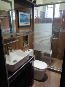 a bathroom with a toilet and a sink and a shower at Avana Hills Tagaytay Villa in Tagaytay