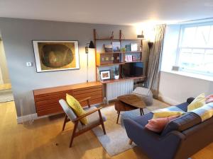 uma sala de estar com um sofá e uma mesa em Stylish two bed flat, city centre, free parking em Wells