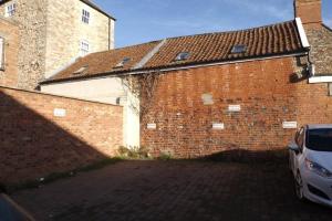 a brick building with a car parked next to it at Stylish two bed flat, city centre, free parking in Wells