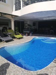 Avana Hills Tagaytay Villa في تاجيتاي: مسبح ازرق كبير بجانب مبنى