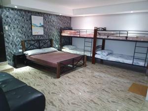 Avana Hills Tagaytay Villa في تاجيتاي: غرفة بسريرين بطابقين وأريكة