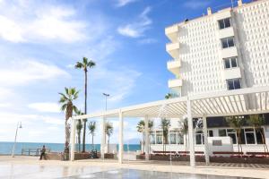 a hotel with palm trees and the ocean in the background at FAY Victoria Beach in Rincón de la Victoria