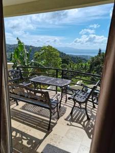 uma mesa e cadeiras numa varanda com vista em Avana Hills Tagaytay Villa em Tagaytay