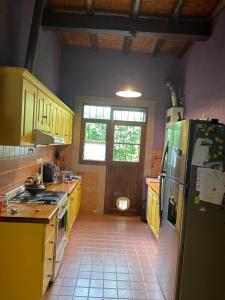 uma cozinha com armários amarelos e um frigorífico em Habitación en casa estilo campo em Luján de Cuyo