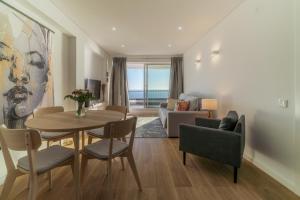 a living room with a table and chairs and a couch at The View House - Sesimbra in Sesimbra