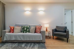 a couch and a chair in a living room at The View House - Sesimbra in Sesimbra