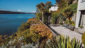 a bench sitting on a path next to a body of water at The Ridge in Menai Bridge