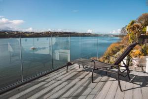 a bench on a deck with a view of the water at The Ridge in Menai Bridge