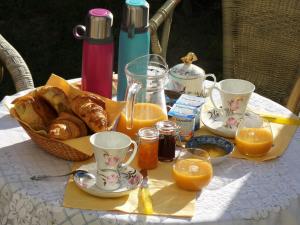 a table with a breakfast of croissants and orange juice at Vue sur Chateau et Loire in Saumur