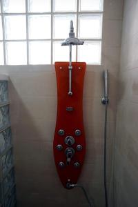 ein Badezimmer mit einem roten Gitarrenofon in der Dusche in der Unterkunft Tetouan Luxury Apartment in Tétouan