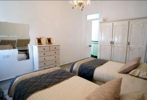Zimmer mit 3 Betten, einer Kommode und einem Schlafzimmer in der Unterkunft Tetouan Luxury Apartment in Tétouan