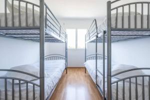 two bunk beds in a room with wooden floors at La Résidence Les Grands Vignobles in Libourne