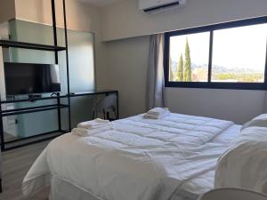 a hotel room with two beds and a large window at Nuevo Hotel Ancasti in San Fernando del Valle de Catamarca