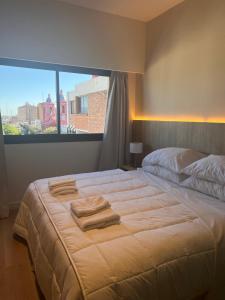 a bedroom with a large bed with towels on it at Nuevo Hotel Ancasti in San Fernando del Valle de Catamarca