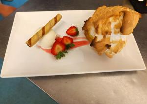 a white plate with a pastry and fruit on it at Dukes Folly Hotel in Southport