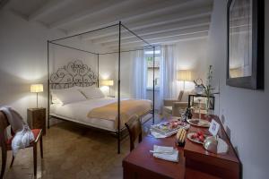 a hotel room with two beds and a table at Relais & Chateaux Palazzo Seneca in Norcia