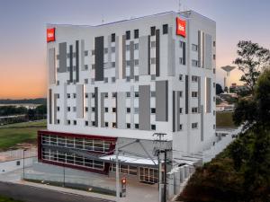 阿鲁雅Ibis Aruja的一座白色的大建筑,上面有红色的标志