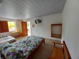 1 dormitorio con 1 cama y TV en la pared en Hotel CHAFO en Leticia