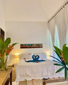 ein Schlafzimmer mit einem weißen Bett mit einer blauen Blume darauf in der Unterkunft Maddekehaoo Eco Mansion in Ko Chang